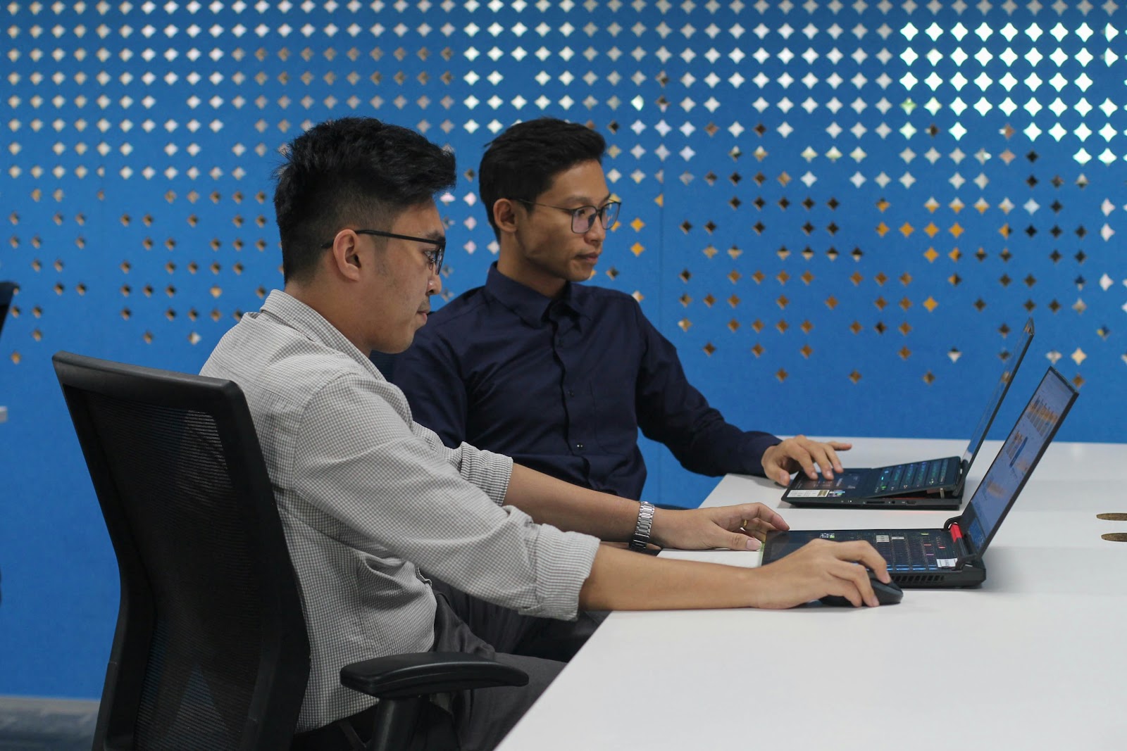 two men using laptops at work